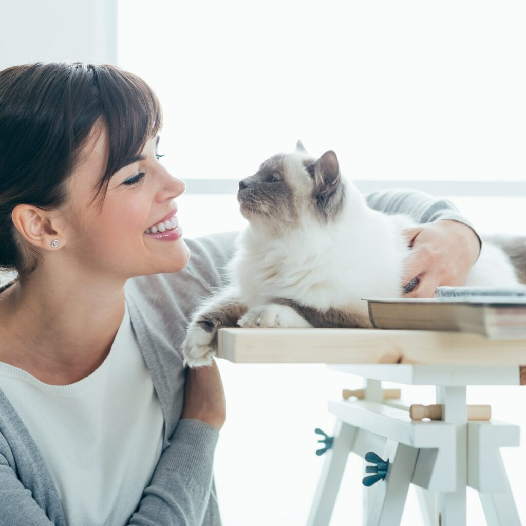 Happy woman cuddling her cat